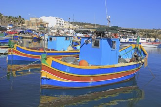 Colourful traditional fishing boats called luzzu in the harbour at Marsaxlokk, Malta, Europe