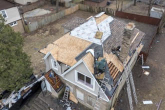 Detroit, Michigan, Workers replace a roof on a vacant house in the Morningside neighborhood. They