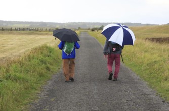 Orford Ness lighthouse Open Day, September 2017, Suffolk, England, UK, two men walking in rain