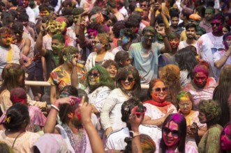 Revellers dancing in the beat of music as they celebrate Holi on a street, the Hindu spring