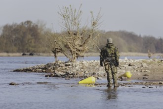 A soldier stands by the Elbe, taken as part of the military exercise 'Wettiner Schwert' with German