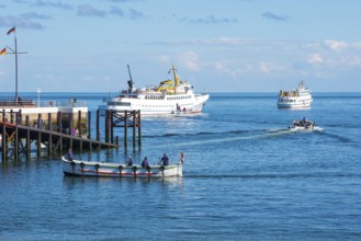 Two white ferries, 'Fair Lady' and 'Lady von Büsum', embarking, embarking off the island of