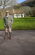 Smartly dressed gentleman out for his morning walk in Bossington, Exmoor national park, Somerset,