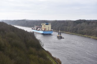 Container ship Laura Maersk is escorted by a tugboat in the Kiel Canal, Schleswig-Holstein,