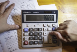 Symbolic photo on the subject of accounting: A calculator stands next to documents on an office