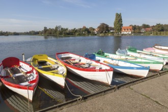 Colourful rowing boats on the Meare boating pond, Thorpeness, Suffolk, England, UK