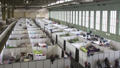 Temporary rooms with beds are set up in an emergency shelter for refugees on 9 December 2015 in a