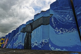 Colourful mural by the sea with a large whale under a cloudy sky, small town of Vila Franca do