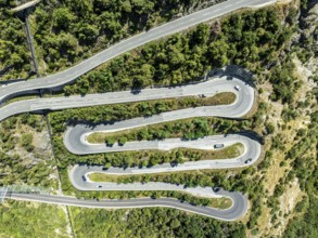 Mountain pass road with multiple hairpins, water pipeline, aerial view, drone shot. Valais,