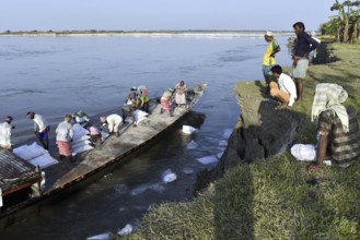 Public Works Department (PWD) of Assam labourer throwing sand bag from boat in the banks of Beki