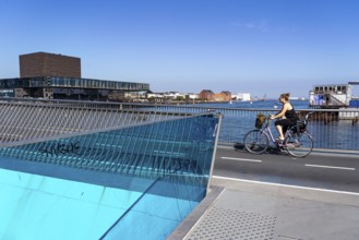 Cyclists on the Inderhavnsbroen cycle and footpath bridge, over the harbour, at Nyhavn, Copenhagen