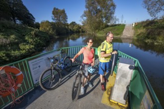 Cyclist, cycle tour, manually operated ferry across the Lippe near Halten am See, on the