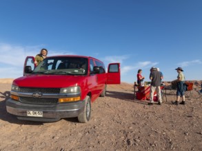 Red car, Chrysler van and travelling group at camping breakfast in Atacama Desert, Chile, South