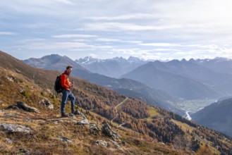 Mountaineer in front of mountain panorama, view from Venet into the Upper Inn Valley, in autumn,