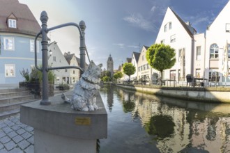 Bronze sculpture by Cornelia Brader: City tomcat Chicco at the city stream, behind it Our Lady's