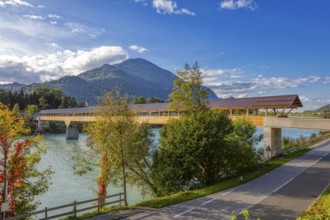 Landscape view of a wooden bridge over a river surrounded by autumnal nature and mountains, Inn