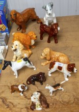 Variety of China dog models of different breeds on display as a lot in auction room, UK