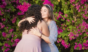 Two women friends hugging outdoors. Girl congratulating and hugging her friend, women's day concept