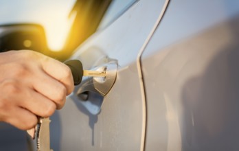 Hands with keys opening the car door. Close-up of hands opening the car door with the key. Concept