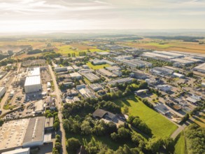 Industrial area with many buildings and roads, surrounded by fields and landscape under a clear