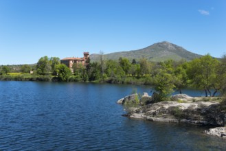 Clear lake next to a building, surrounded by nature and mountains under a blue sky, palace, Palacio