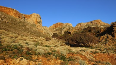 Morning light, landscape with sunny hills and rock formations under a clear blue sky, Gramvoussa