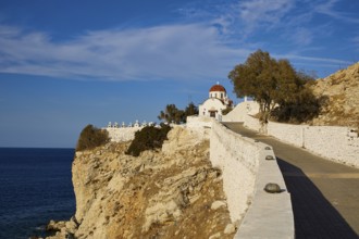 A church on a cliff overlooking the sea on a clear, sunny day, Agios Nikolaos church, cemetery,