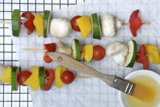 Colourful vegetable skewers with brush and marinade, raw barbecue skewer