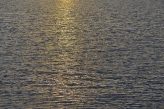 Light reflections of the evening sun on the wavy water surface, North Sea, Norddeich, Lower Saxony,