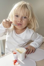 Portrait of blonde girl, 3 years old, having lunch in Ystad, Skåne County, Sweden, Scandinavia,