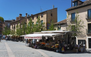 Sunny street scene with market stall, buildings and people in a town, Plaza de los Dolores, San