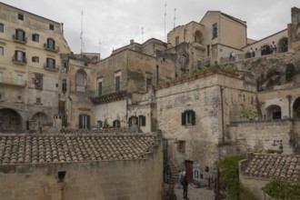 Historic Italian town view with old stone buildings and narrow streets under a grey sky, old town