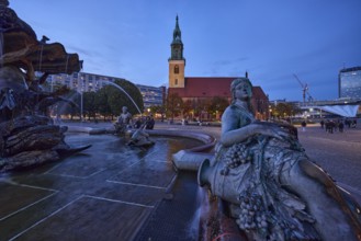 Bronze figure of a woman with grapes of the Neptune Fountain and St. Mary's Church at dusk,