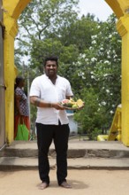 Sri Lankan man, 33 years old, with offerings at the Buddhist temple Ruhunu Maha Kataragama