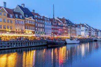 Colourful houses, restaurants and historic ships on the Nyhavn canal and harbour at dusk,