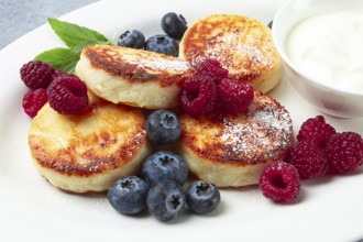 Breakfast, cottage cheese cakes, with fresh berries, and sour cream, top view, close-up, no people