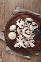 Fresh mushrooms, chopped, in a wooden bowl, whole, top view, no people