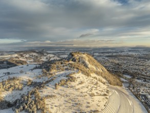 Aerial view of the snow-covered Hegau volcano Hohentwiel with Germany's largest castle ruins on a