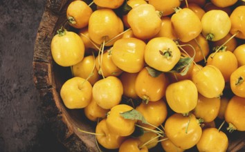 Yellow small apples, Chinese varieties, in a wooden bowl, top view, no people