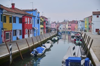 Colorful houses beside the waterway at 'Fondamenta della Pescheria' with boats lying in the water