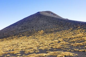 Group of hikers walking around crater rim, Etna, Sicily, Italy, Europe