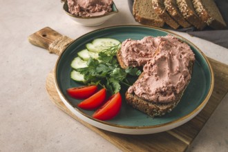 Liver meat pate spread on rye bread, breakfast, close-up, beige background. no people, selective