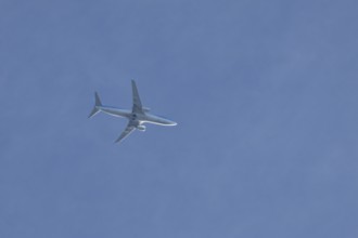 Boeing 737 jet passenger aircraft of TUI holidays flying in a blue sky, England, United Kingdom,