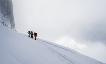 Dramatic atmosphere, Ski tourers, Snowy mountain landscape, Bernese Alps, Bernese Oberland,