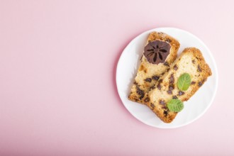 Homemade cake with raisins and dried persimmon on a pink pastel background. Top view, flat lay,