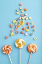 Various caramel candies on blue pastel background. close up, top view, flat lay