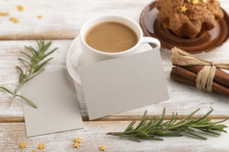 Gray paper business card mockup with cup of coffee and cake on white wooden background. Blank, side