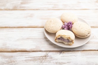 Meringues cakes on a white wooden background. Side view, copy space, close up