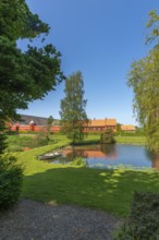 Farm building of Hesselagergaard Manor with park, lake, rowing boat, Fyn, Fyn Island, Denmark,