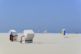 Colourful beach chairs on the beach surrounded by sand, heat streaks on the horizon, North Sea,